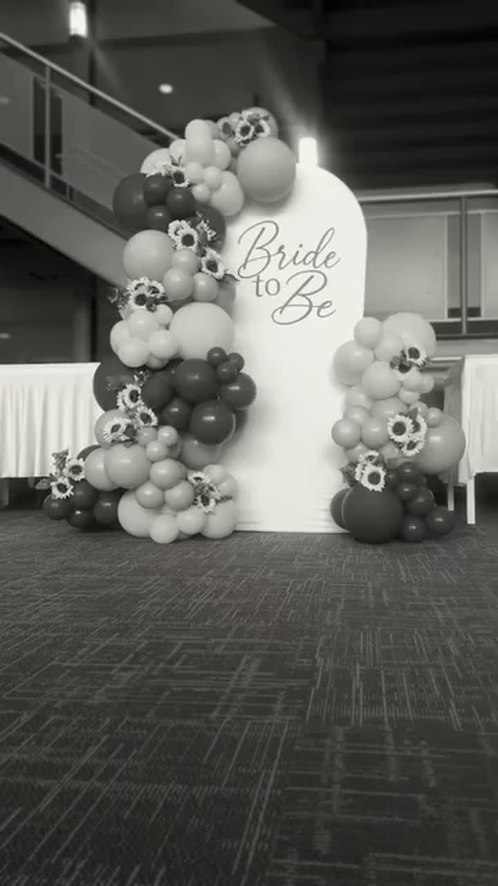 Bridal shower setup with blue and sunflower décor, backdrop and styled tables